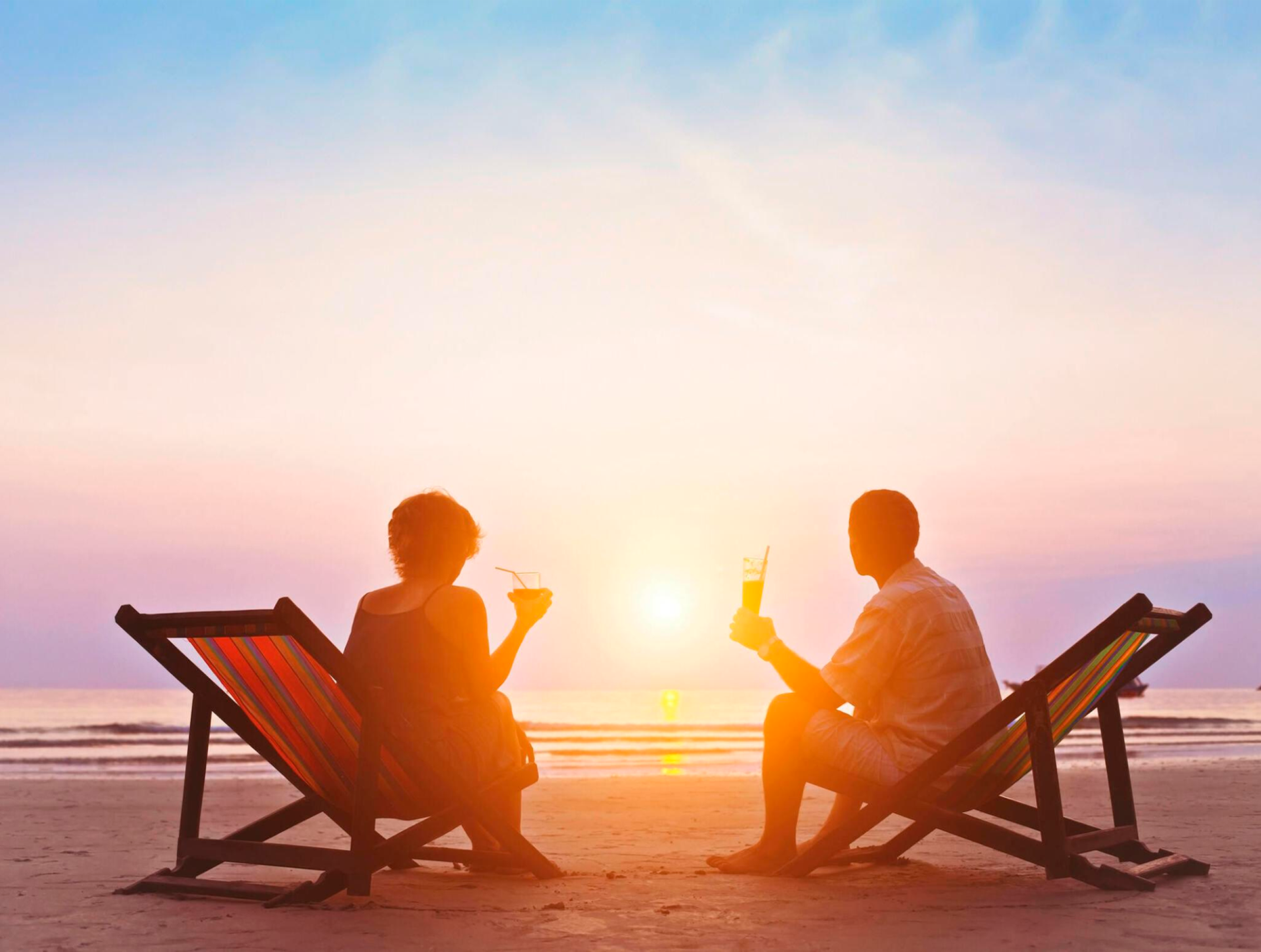 Couple having a drink on beautiful sunset beach of Aruba